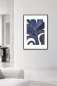 Preview: PETULA indigo abstract wall art with black frame in a bright contemporary living room